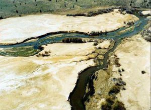 Taken around 2000, this photo shows mine tailings deposits along Silver Bow Creek, a primary headwater of the Clark Fork River. Tailings are particularly harmful to aquatic life. Ongoing remediation and restoration have greatly improved the health of the creek from Butte to Ramsay; work is underway on the remaining contaminated sections.